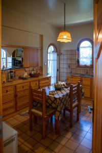 una cocina con mesa y sillas y una cocina con mesa y sillón. en All Seasons Guest House, en Moscháton