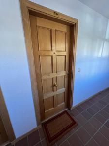 Cette chambre dispose de carrelage et d'une porte en bois. dans l'établissement LOS VALLES SKY, à Sierra Nevada