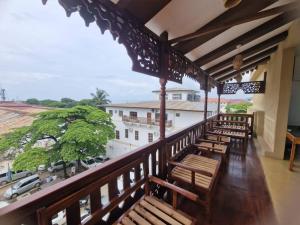 a balcony with wooden benches and a view of a street at Kahawa Sunset View Zanzibar in Zanzibar City