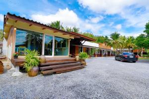 a house with a car parked in a parking lot at Aonang Privacy Resort in Ao Nang Beach