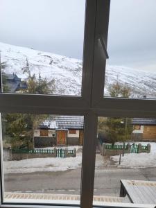 - une vue depuis la fenêtre d'une cour recouverte de neige dans l'établissement ALCAZABA SKY, à Sierra Nevada