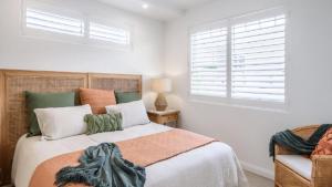 a bedroom with a bed and a window and a chair at Watersea By The Bay Unit 2, waterfront, walk to shop&restaurants in Umina
