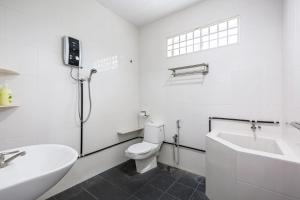 a white bathroom with a toilet and a sink at Seaside Private Bungalow, Tg Bungah in Tanjung Bungah