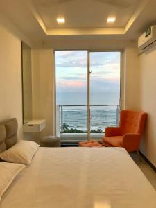 sypialnia z łóżkiem i krzesłem oraz dużym oknem w obiekcie Green Star City Apartment w mieście Dehiwala-Mount Lavinia