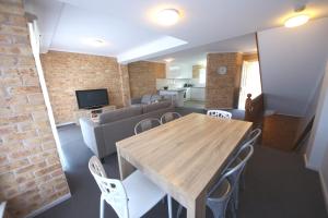 a living room with a wooden table and chairs at Ocean Shores 4 8 Paragon Ave SWR in South West Rocks