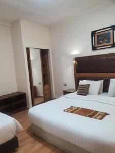 Habitación de hotel con 2 camas y espejo en Aghadeer Hotel, en Amán