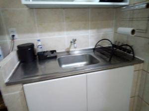 a kitchen counter with a sink in a room at apartamento in Recife