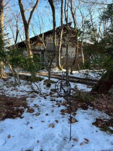 a pole in the snow in front of a house at King's house in Hakuba