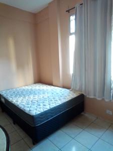 een bed in een kamer met een raam bij apartamento in Recife