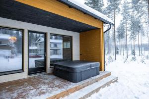 eine abgeschirmte Veranda eines Hauses im Schnee in der Unterkunft Villa Blueberry in Rovaniemi