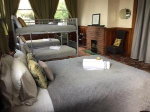 a bedroom with two bunk beds and a fireplace at Royal Mail Hotel in Lumsden