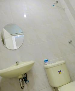 a bathroom with a sink and a toilet and a mirror at My Lovely Apartment in Dipolog