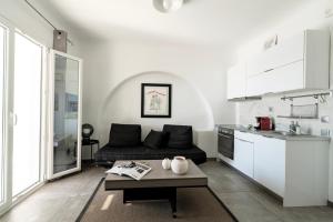 a living room with a couch and a table in a kitchen at Panoramic Aegean Residence At Elia Beach Mykonos - Private & Exclusive in Elia Beach