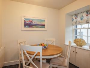 un tavolo da pranzo con una ciotola di frutta sopra di Lydia Cottage - Cromarty a Cromarty Altre 16 foto