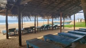 ヒッカドゥワにあるGolden Beach Guest House and Restaurantの海岸のテーブルと椅子
