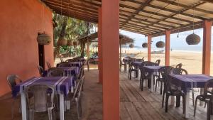 um restaurante com mesas e cadeiras roxas na praia em Golden Beach Guest House and Restaurant em Hikkaduwa