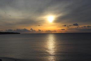 CENTRAL URBAN LUXURY SEA VIEW APT SINCE 2009 في إرابيترا: غروب الشمس على المحيط مع الشمس في السماء