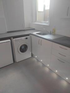 a kitchen with a washing machine and a sink at Modern 2 bed house sleeps 6 in Portsmouth +27 photos