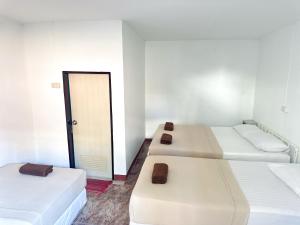 3 camas en una habitación con puerta en Bang sit Guest House en Islas Phi Phi