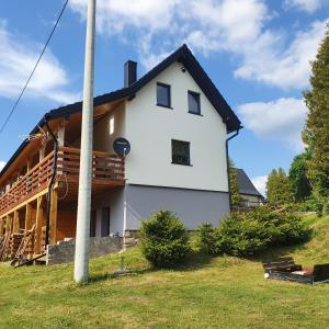 a white house with a gambrel roof at Apartamenty Dzika Orlica in Zieleniec