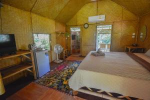 a bedroom with a bed and a tv in a room at Ratanaporn Green in Phuket