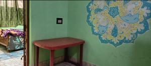 einen roten Stuhl in einem Zimmer mit grüner Wand in der Unterkunft ANBU RAMANA Guest House in Tiruvannāmalai
