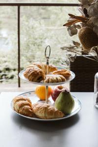 dois pratos de pastelaria e fruta numa mesa em "On Burgum Pond" Cottages em Maleny