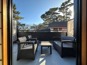 Un patio con sillas y una mesa en el balcón. en Minato Oasis Numazu / 沼津観光の中心、伊豆観光の拠点に好立地！沼津港に位置し交通・飲食・コンビニ等至便です！ en Numazu