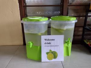 two green plastic containers with a sign in front of them at Sungai Tiny House 2 in Raub