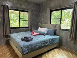 1 dormitorio con 1 cama con toallas en บ้านสวนริมธาร โฮมสเตย์ ท้ายเหมือง พังงา 