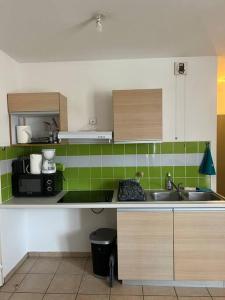 a kitchen with a sink and a microwave at Lil'appart in Saint-Denis