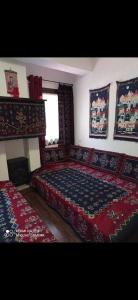 1 dormitorio con 1 cama con colcha roja en ΟΡΕΙΝΟ ΟΝΕΙΡΟ en Anilio Metsovo