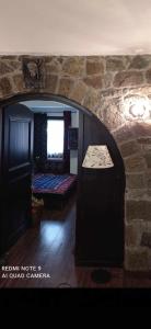 Cette chambre est dotée d'un mur en pierre et d'un lit. dans l'établissement ΟΡΕΙΝΟ ΟΝΕΙΡΟ, à Anilio
