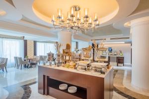 um quarto amplo com um buffet com um lustre em Riviera Rayhaan by Rotana Doha em Doha