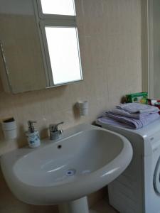 La salle de bains est pourvue d'un lavabo blanc et d'un miroir. dans l'établissement appartamento incantevole a Ospedaletti(Sanremo), à Ospedaletti