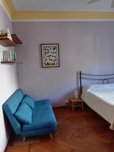 - une chambre avec une chaise bleue et un lit dans l'établissement appartamento incantevole a Ospedaletti(Sanremo), à Ospedaletti