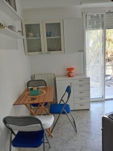 - une cuisine avec une table et des chaises dans la chambre dans l'établissement appartamento incantevole a Ospedaletti(Sanremo), à Ospedaletti