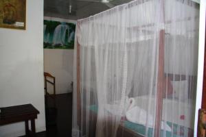 a window with a curtain in a room at Kolon Resort Sigiriya in Sigiriya