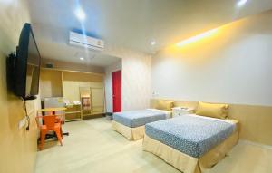 een hotelkamer met 2 bedden en een flatscreen-tv bij พาลาซิโอ เดอ ปราณี in Phetchaburi