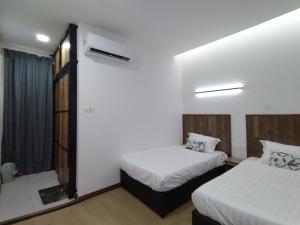 a hotel room with two beds and a window at Greenery Studio, Kubot a Sentral in Tawau