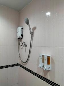 a shower in a bathroom with a blow dryer on a wall at พลอยฟ้ารีสอร์ทเขาเต่า Ployfarresortkhaotao in Khao Tao