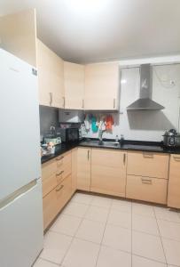 馬德里的住宿－安静双人房，厨房配有木制橱柜和白色瓷砖地板。
