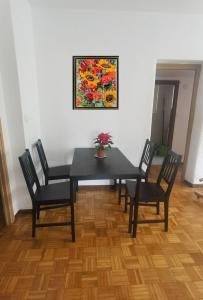 安静双人房 في مدريد: غرفة طعام مع طاولة سوداء وأربعة كراسي