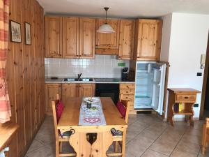 una cucina con armadi in legno e tavolo in legno di Appartamento Monte Rosa a Champoluc