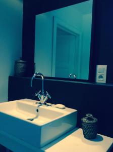 a bathroom with a sink and a large mirror at Manoir au Bois in Braine-le-Château