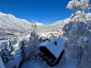 a house covered in snow with snow covered trees at Nid de charme au pied des pistes in Saint-Martin-de-Belleville
