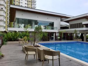 um edifício com piscina, mesa e cadeiras em MesaVerte Residence By Ms German em Cagayan de Oro