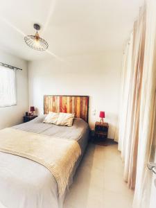 a bedroom with a large bed and a lamp at Villa Orethaga Piscine 10 pers porto Vecchio in Porto-Vecchio