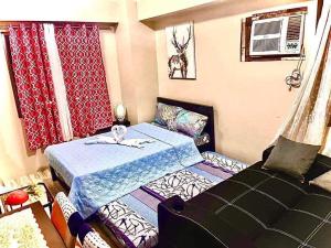 een kleine slaapkamer met een bed en een bank bij Across Sm City Cebu Sunvida Tower Studio Unit in Cebu City