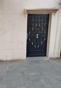 Una puerta de metal negro con mariposas doradas. en العين الهيلي مصباح ب 7, en Al Ain